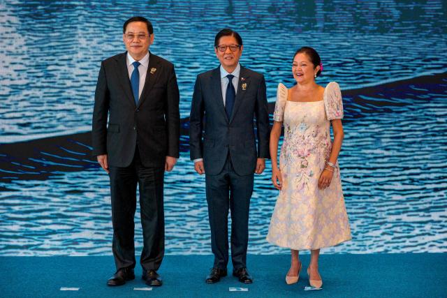 Laos Prime Minister Sonexay Siphandone (L) poses for a photo with Philippine President Ferdinand Marcos Jr. and Liza Araneta Marcos during a welcome ceremony for the 48th Association of Southeast Asian Nations (ASEAN) summit in Cebu, central Philippines on May 8, 2026. (Photo by Ezra Acayan / POOL / AFP)