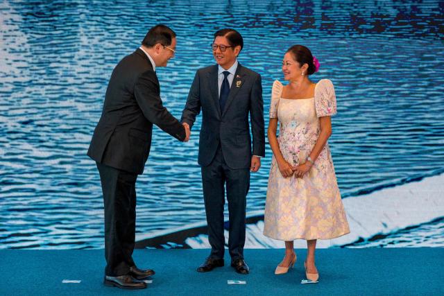 Laos Prime Minister Sonexay Siphandone (L) is greeted by Philippine President Ferdinand Marcos Jr. and Liza Araneta Marcos during a welcome ceremony for the 48th Association of Southeast Asian Nations (ASEAN) summit in Cebu, central Philippines on May 8, 2026. (Photo by Ezra Acayan / POOL / AFP)