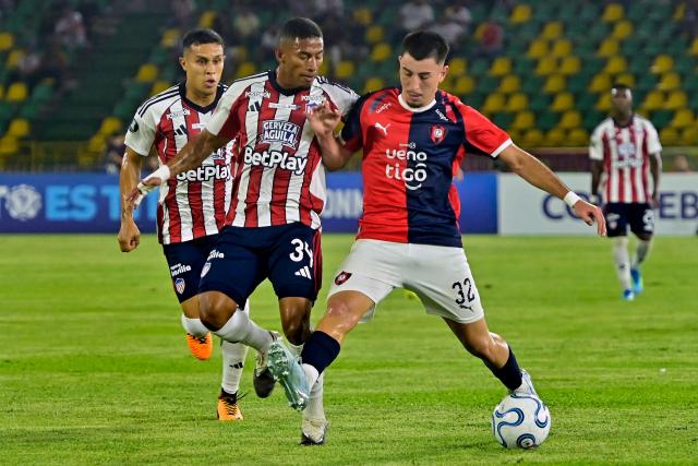Junior's defender #34 Jhonier Guerrero and Cerro Porteno's midfielder #32 Cesar Bobadilla fight for the ball during the Copa Libertadores group stage football match between Colombia's Junior and Paraguay's Cerro Porteno at the Olimpico Jaime Moron Leon stadium in Cartagena, Bolivar department, Colombia on May 7, 2026. (Photo by Manuel PEDRAZA / AFP)