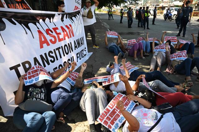 Environmental activists holding placards lie on the ground during a rally coinciding with the opening ceremony of the Association of Southeast Asian Nations (ASEAN)summit in Cebu on May 8, 2026. (Photo by Ted ALJIBE / AFP)