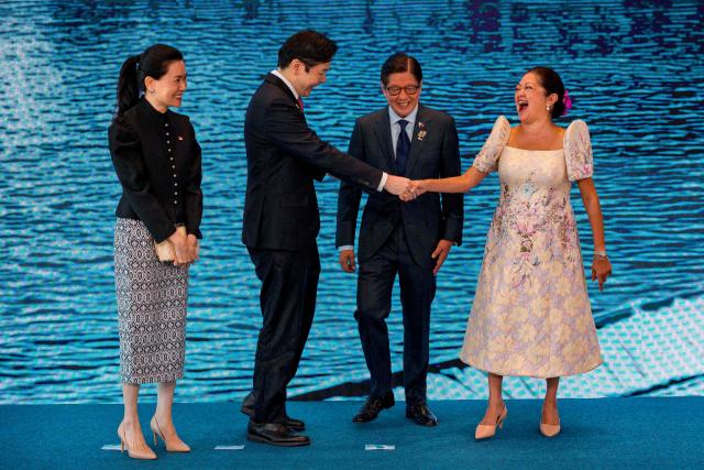 Singapore Prime Minister Lawrence Wong (2nd-L) and his wife Loo Tze Lui are greeted by Philippine President Ferdinand Marcos Jr. and his wife Liza Araneta Marcos during a welcome ceremony for the 48th Association of Southeast Asian Nations (ASEAN) summit in Cebu, central Philippines on May 8, 2026. (Photo by Ezra Acayan / POOL / AFP)