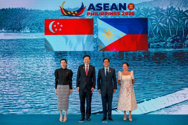 Singapore Prime Minister Lawrence Wong (2nd-L) and his wife Loo Tze Lui pose for a photo with Philippine President Ferdinand Marcos Jr. and his wife Liza Araneta Marcos during a welcome ceremony for the 48th Association of Southeast Asian Nations (ASEAN) summit in Cebu, central Philippines on May 8, 2026. (Photo by Ezra Acayan / POOL / AFP)