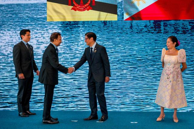 Brunei Sultan Hassanal Bolkiah (2nd-L) and his son Prince Abdul Mateen are greeted by Philippine President Ferdinand Marcos Jr. and his wife Liza Araneta Marcos during a welcome ceremony for the 48th Association of Southeast Asian Nations (ASEAN) summit in Cebu, central Philippines on May 8, 2026. (Photo by Ezra Acayan / POOL / AFP)