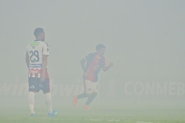 Junior's forward #29 Teofilo Gutierrez waits for the smoke to clear during the Copa Libertadores group stage football match between Colombia's Junior and Paraguay's Cerro Porteno at the Olimpico Jaime Moron Leon stadium in Cartagena, Bolivar department, Colombia on May 7, 2026. (Photo by Manuel PEDRAZA / AFP)