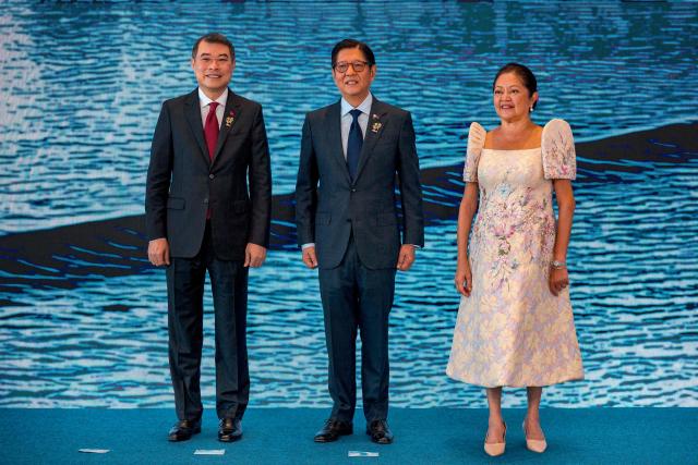 Vietnam Prime Minister Le Minh Hung (L) poses for a photo with Philippine President Ferdinand Marcos Jr. and his wife Liza Araneta Marcos during a welcome ceremony for the 48th Association of Southeast Asian Nations (ASEAN) summit in Cebu, central Philippines on May 8, 2026. (Photo by Ezra Acayan / POOL / AFP)