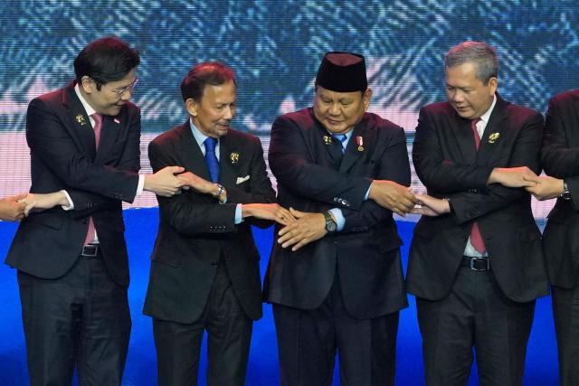 (L-R) Singapore's Prime Minister Lawrence Wong, Brunei's Sultan Hassanal Bolkiah, Indonesia's President Prabowo Subianto and Cambodia's Prime Minister Hun Manet hold hands for a group photo during a welcome ceremony for the 48th Association of Southeast Asian Nations (ASEAN) summit in Cebu, central Philippines on May 8, 2026. (Photo by Aaron FAVILA / POOL / AFP)