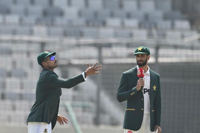 Bangladesh captain Najmul Hossain Shanto (L) tosses a coin as Pakistan captain Shan Masood (R) looks on during the toss before the start of the first day of the first Test cricket match between Bangladesh and Pakistan at Sher-e-Bangla National Cricket Stadium in Dhaka on May 8, 2026. (Photo by MUNIR UZ ZAMAN / AFP)