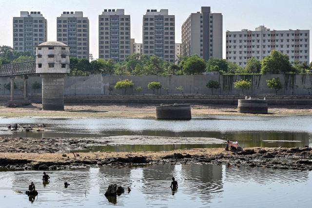People search for reusable things in the Sabarmati River in Ahmedabad on May 8, 2026. (Photo by Shammi MEHRA / AFP)