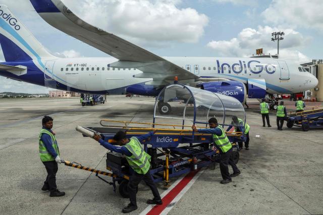 Ground staff members make preparations for an IndiGo Airlines aircraft to take off at Biju Patnaik International Airport in Bhubaneswar on May 8, 2026. (Photo by Niharika KULKARNI / AFP)