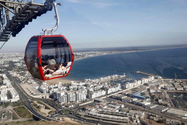 Visitors ride the cable car to Agadir Oufella, on the heights of the coastal city of Agadir, on May 7, 2026. The Agadir cable car is a recent installation connecting the city of Agadir to the historical hill of Agadir Oufella, which is the location of an old fort much of which was affected by the earthquake that struck the city in 1960. (Photo by Abdel Majid BZIOUAT / AFP)