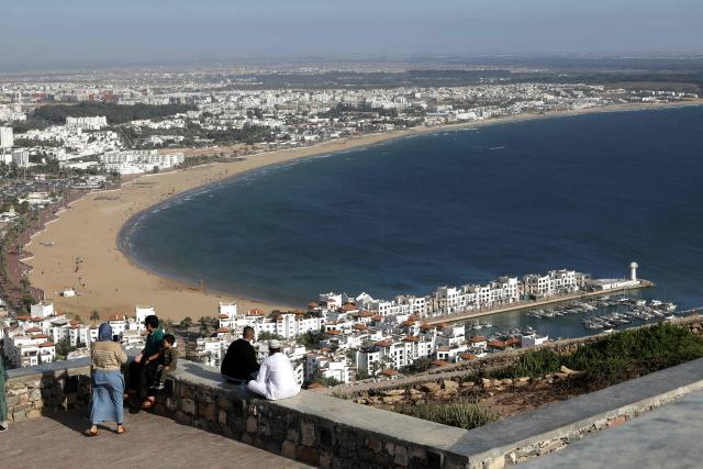 Visitors look down on the harbour, housing and the Atlantic Ocean from the Kasbah of Agadir Oufella, on the heights of what used to be the old city of Agadir, on May 7, 2026. (Photo by Abdel Majid BZIOUAT / AFP)