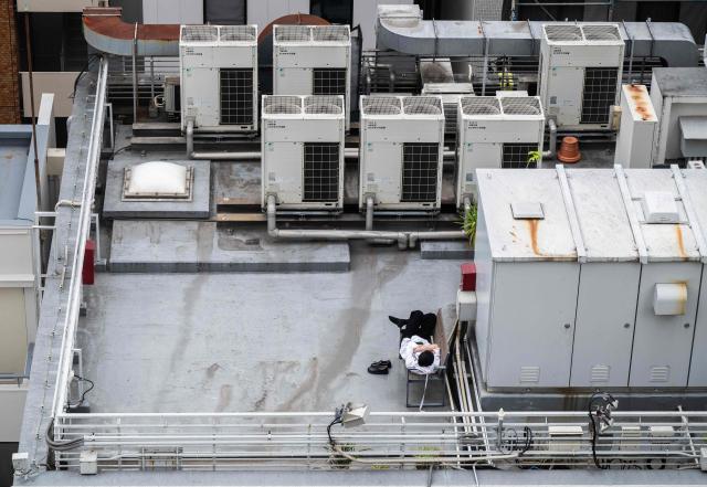A businessman takes a rest on the top of an office building in Tokyo on May 8, 2026. (Photo by Andrew CABALLERO-REYNOLDS / AFP)