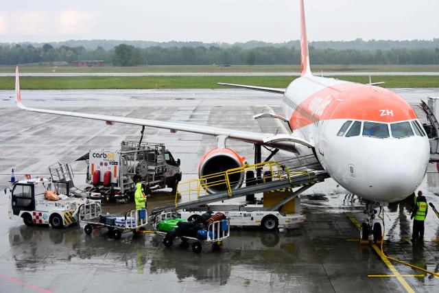 (FILES) A worker loads luggage onto an Easyjet aircraft as a fuel truck "CarbOil" services the plane at Milan's Malpensa Airport on April 13, 2026. The war in the Middle East and the closure of the Strait of Hormuz have caused a surge in aviation fuel prices and raised concerns about potential shortages this summer. On May 8, 2026, the EU Aviation Safety Agency (EASA) is expected to release recommendations on whether or not to use Jet A, a kerosene produced in the United States but not currently distributed in Europe for technical reasons. (Photo by Stefano Rellandini / AFP)