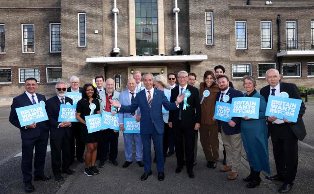 Reform UK leader Nigel Farage poses for a picture with Reform UK members outside Havering Town Hall a day after local elections in east London on May 8, 2026. Farage's anti-immigrant Reform UK has gained over 350 seats while Labour has lost over 240 across 40 of the 136 English councils to announce results so far. (Photo by Toby Shepheard / AFP)