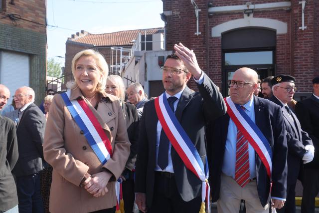 President of French far right Rassemblement National parliamentary group Marine Le Pen (L) and mayor of Oignies Francois Vial (C) attend a ceremony marking the 81st anniversary of VE Day, or Victory in Europe Day, which commemorates the end of World War II, in Oignies, northern France, on May 8, 2026. (Photo by Francois LO PRESTI / AFP)
