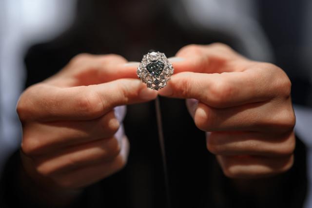 A Christie’s member of staff shows a triangular-shaped fancy vivid blue-green diamond weighing 5.50 carats, known as "The Ocean Dream", during a press preview at Christie’s auction house in Geneva, on May 7, 2026. The Ocean Dream, presented by Christie's as the largest fancy vivid blue-green diamond known to exist and valued 7,000,000 to 10,000,000 CHF (7,649,084 to 10 927 222 Euro) will be offered during the Magnificent Jewels auction, on May 13, 2026. (Photo by Fabrice COFFRINI / AFP)