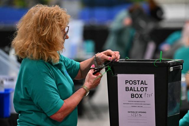 A staff member opens a post ballot box the morning after parliamentary elections at the Dewars Centre in Perth, Perthshire, Scotland on May 8, 2026. (Photo by ANDY BUCHANAN / AFP)
