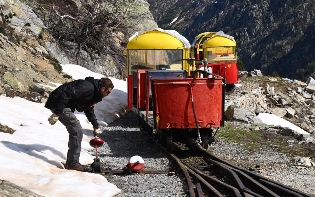 An employee checks the railway switch to allow the little train, a historic tourist railway, to pass in Artouste near Laruns, south-western France, on May 7, 2026. The Artouste little train is located in the Ossau Valley, in the Pyrenees-Atlantiques department of France. This historic tourist railway offers a mountain excursion at an altitude of over 2,000 meters. It travels 10 kilometers on its narrow-gauge track. It is the highest narrow-gauge railway in Europe. (Photo by Gaizka IROZ / AFP)