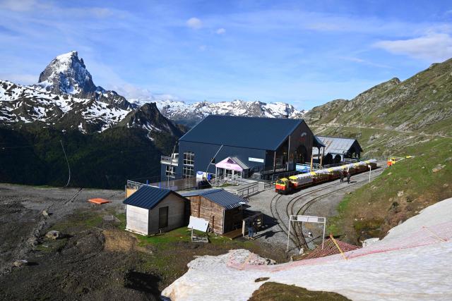 This photograph shows the station of the little train, a historic tourist railway, with the Pic d'Ossau mountain peak in the background in Artouste near Laruns, south-western France, on May 7, 2026. The Artouste little train is located in the Ossau Valley, in the Pyrenees-Atlantiques department of France. This historic tourist railway offers a mountain excursion at an altitude of over 2,000 meters. It travels 10 kilometers on its narrow-gauge track. It is the highest narrow-gauge railway in Europe. (Photo by Gaizka IROZ / AFP)