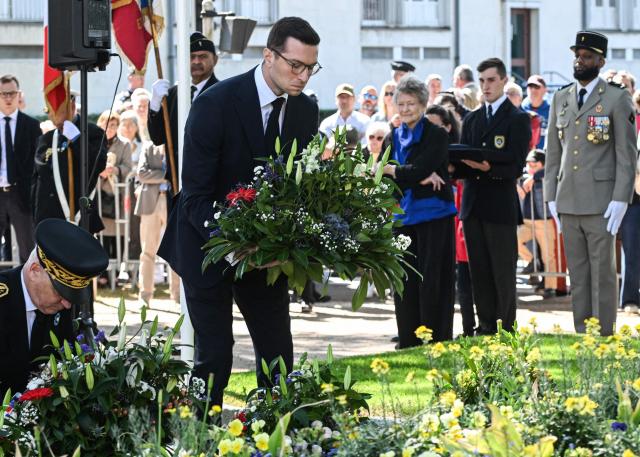 French far-right Rassemblement National RN party's President Jordan Bardella (C) deposits a flower wreath as he attends a ceremony marking the 81st anniversary of VE Day, or Victory in Europe Day, which commemorates the end of World War II, in La Fleche, north-western France, on May 8, 2026. (Photo by Sebastien Salom-Gomis / AFP)