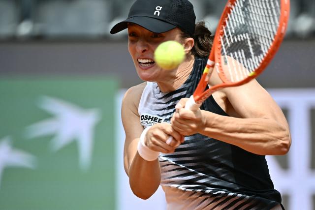 Poland's Iga Swiatek plays a backhand return to US Caty McNally during their women's singles match of the WTA Rome Open tennis tournament at the Foro Italico in Rome on May 8, 2026. (Photo by Filippo MONTEFORTE / AFP)