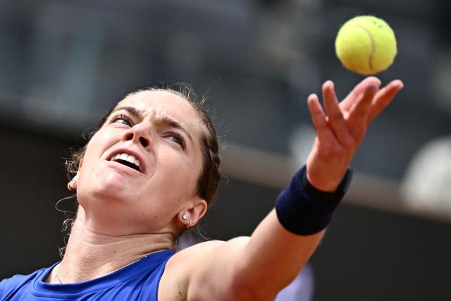 US Caty McNally serves to Poland's Iga Swiatek during their women's singles match of the WTA Rome Open tennis tournament at the Foro Italico in Rome on May 8, 2026. (Photo by Filippo MONTEFORTE / AFP)