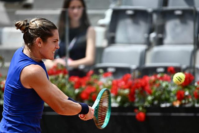 US Caty McNally plays a backhand return to Poland's Iga Swiatek during their women's singles match of the WTA Rome Open tennis tournament at the Foro Italico in Rome on May 8, 2026. (Photo by Filippo MONTEFORTE / AFP)