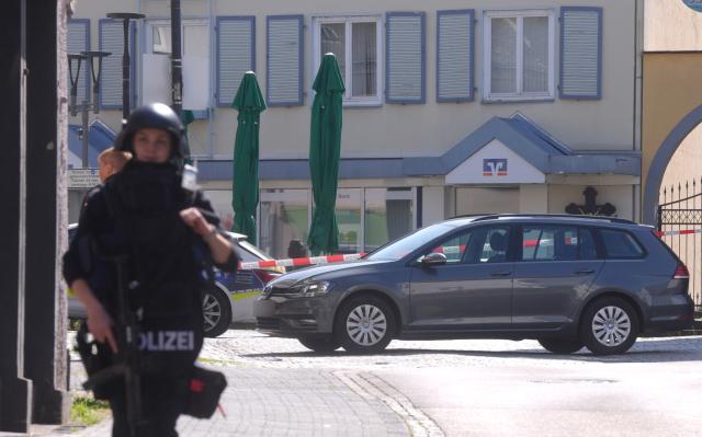 Police stand in front of a bank where suspects have taken multiple hostages in the western German town of Sinzig, police confirmed on May 8, 2026. Police said in a statement that there were believed to be "several hostage-takers and hostages inside the bank," and that the driver of a cash transport vehicle was among those being held. (Photo by Thomas Frey / dpa / AFP) / Germany OUT