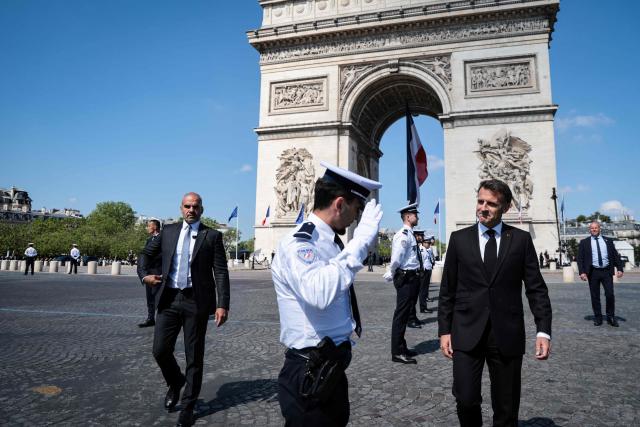 France's President Emmanuel Macron walks in front of the Arc de Triomphe for a ceremony marking the 81st anniversary of Victory in Europe Day, which commemorates the end of the Second World War in Europe, in Paris on May 8, 2026. (Photo by Ludovic MARIN / POOL / AFP)
