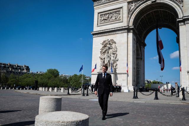France's President Emmanuel Macron walks in front of the Arc de Triomphe for a ceremony marking the 81st anniversary of Victory in Europe Day, which commemorates the end of the Second World War in Europe, in Paris on May 8, 2026. (Photo by Ludovic MARIN / POOL / AFP)