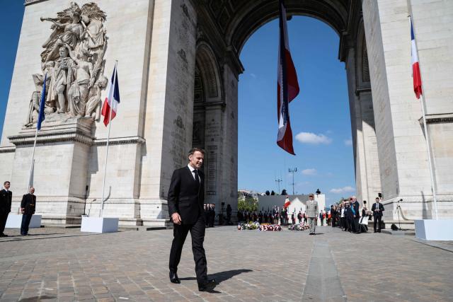 France's President Emmanuel Macron walks in front of the Arc de Triomphe for a ceremony marking the 81st anniversary of Victory in Europe Day, which commemorates the end of the Second World War in Europe, in Paris on May 8, 2026. (Photo by Ludovic MARIN / POOL / AFP)