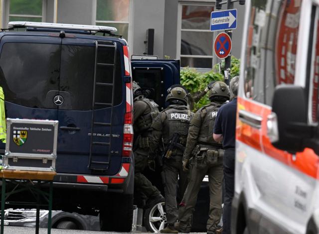 Police and rescue services are seen near a bank, where bank robbers have taken multiple hostages in Sinzig, western Germany on May 8, 2026. Police said there were believed to be "several hostage-takers and hostages inside the bank," and that the driver of a cash transport vehicle was among those being held. (Photo by Roberto Pfeil / AFP)