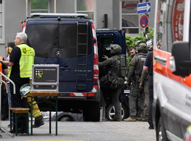 Police and rescue services are seen near a bank, where bank robbers have taken multiple hostages in Sinzig, western Germany on May 8, 2026. Police said there were believed to be "several hostage-takers and hostages inside the bank," and that the driver of a cash transport vehicle was among those being held. (Photo by Roberto Pfeil / AFP)