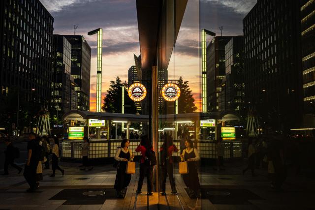 People walk down the street at the end of the work day to a cafe in Tokyo on May 8, 2026. (Photo by Philip FONG / AFP)