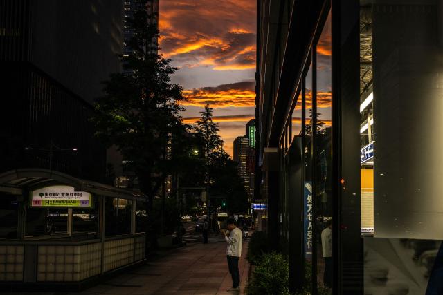 A man stands in front of a shop at the end of the work day in Tokyo on May 8, 2026. (Photo by Philip FONG / AFP)