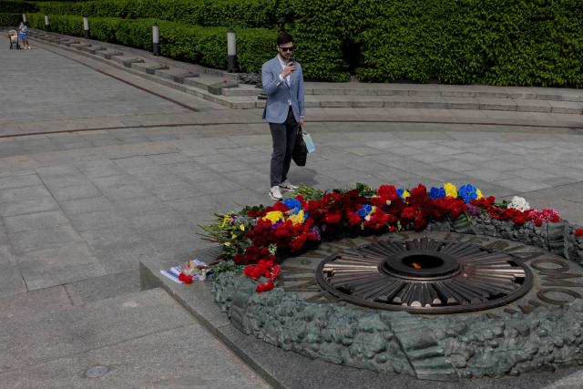 A man takes photos of the Tomb of the Unknown Soldier at the WWII memorial on the 81st anniversary of VE Day, or Victory in Europe Day, or Day of Remembrance, which commemorates the end of World War II, in Kyiv, on May 8, 2026, amid the Russian invasion of Ukraine. (Photo by Tetiana DZHAFAROVA / AFP)