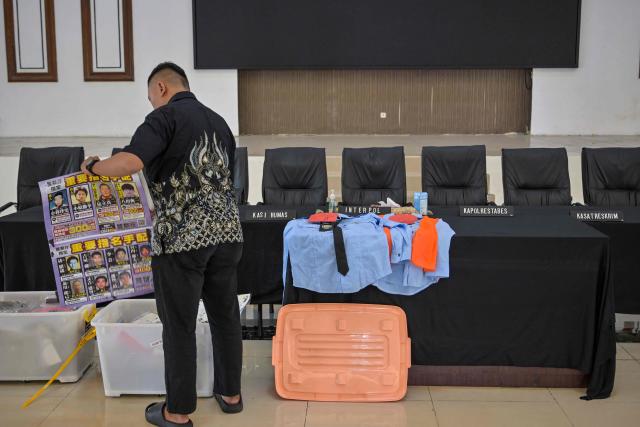 An Indonesian police displays evidence before authorities hold a press conference following the arrest of dozens of suspects in an online fraud case in Surabaya on May 8, 2026. Dozens of Chinese, Japanese, and Taiwanese nationals have been arrested in Indonesia in connection with an online fraud case that has cost victims millions of dollars. (Photo by JUNI KRISWANTO / AFP)