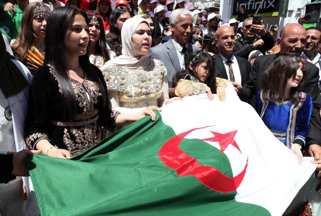 Algerians hold the national flag as they take part in a commemoration marking the anniversary of the "1945 Setif massacres" in the eastern city of Setif on May 8, 2026. France announced on May 8,  the return of its ambassador to Algeria, coinciding with a ministerial visit aimed at “building trusting relations” and “restoring effective dialogue” with Algiers, following nearly two years of diplomatic crisis between the two countries. (Photo by AFP)