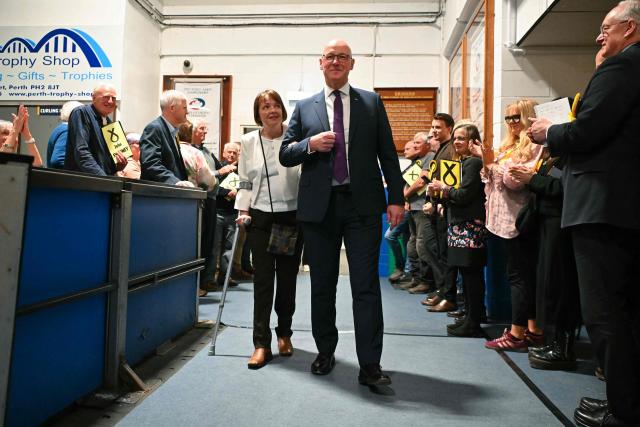 Scotland's First Minister and Scottish National Party (SNP) leader John Swinney and his wife Elizabeth receive an applause as they arrive to attend a vote-counting centre the day after parliamentary elections at the Dewars Centre in Perth, Perthshire, Scotland on May 8, 2026. (Photo by ANDY BUCHANAN / AFP)