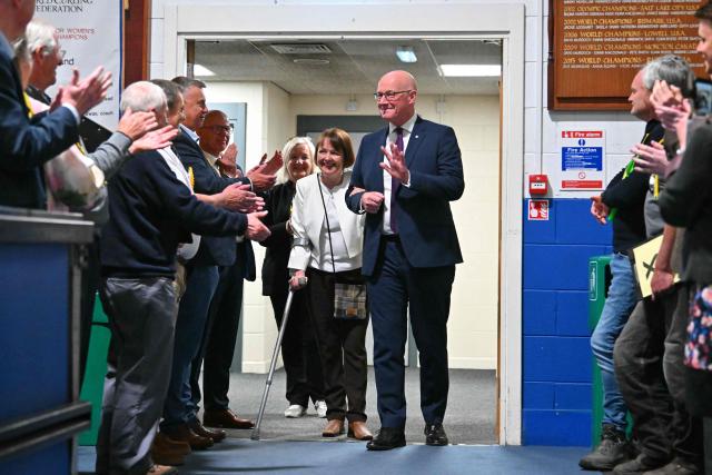 Scotland's First Minister and Scottish National Party (SNP) leader John Swinney and his wife Elizabeth receive an applause as they arrive to attend a vote-counting centre the day after parliamentary elections at the Dewars Centre in Perth, Perthshire, Scotland on May 8, 2026. (Photo by ANDY BUCHANAN / AFP)