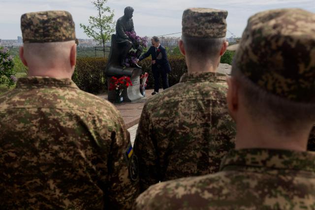 Ukraine's National Guard soldiers stand in front of Monument of Leonid Bykov, Ukrainian actor and director, dedicated to Soviet military pilots who died during World War II, on the Day of Remembrance and Victory over Nazism in World War II, at the Park of Eternal Glory in Kyiv on May 8, 2026, amid the Russian invasion of Ukraine. (Photo by Tetiana DZHAFAROVA / AFP)