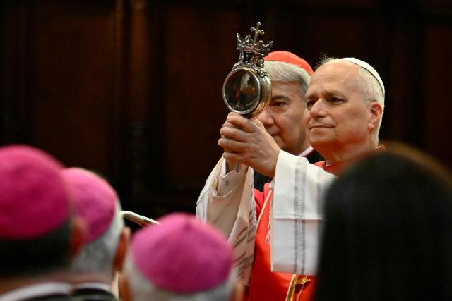 Pope Leo XIV holds the ampulla containing the blood of San Gennaro (Saint Januarius, patron of Naples) at Naples Cathedral as part of a pastoral visit in Naples on May 8, 2026. (Photo by Alberto PIZZOLI / AFP)