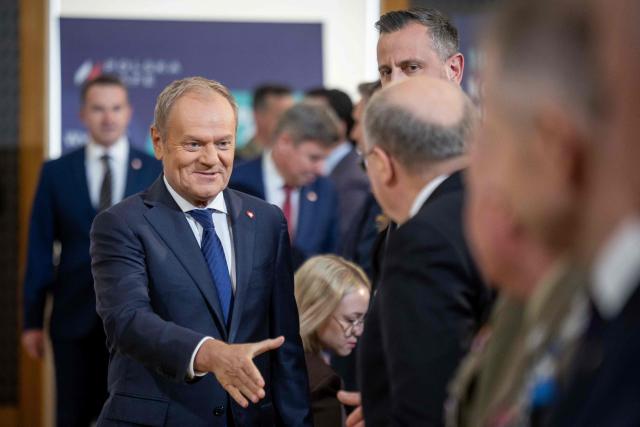 Poland's Prime Minister Donald Tusk (L) shakes hands with EU Commissioner Andrius Kubilius after the signing of the SAFE loan agreement between the European Union and Poland at the Chancellery of the Polish Prime Minister in Warsaw on May 8, 2026. Poland participates in the new EU programme called SAFE (Security Action For Europe) that came into effect last year and under which countries can get EU loans to buy weapons and expand defence manufacturing. Poland on May 8 became the first country to sign the loan agreement to fund the modernisation of its military and arms industry, under which it will receive nearly 44 billion euros (USD 52 million). (Photo by Wojtek RADWANSKI / AFP)