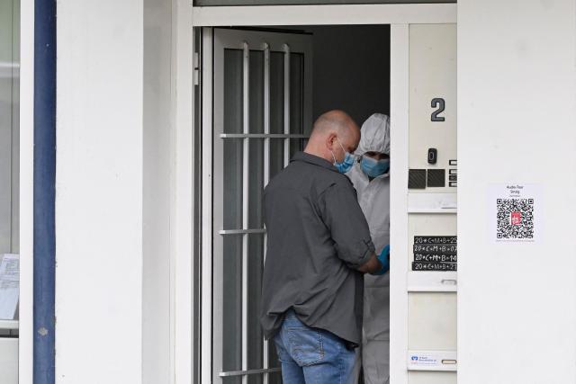 Forensic police officers inspect an entrance to a bank following the robbery and hostage situation at the bank in Sinzig, western Germany on May 8, 2026. The hostage situation at a German bank ended on May 8 after a special police unit freed two people unharmed from a vault, but the suspects escaped and are on the run, police said. (Photo by Roberto Pfeil / AFP)