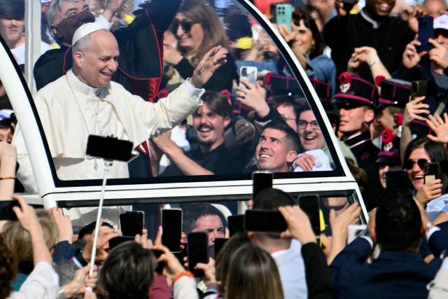 Pope Leo XIV waves to the crowd at Piazza del Plebiscito before a holy mass as part of a pastoral visit in Naples on May 8, 2026. (Photo by Alberto PIZZOLI / AFP)