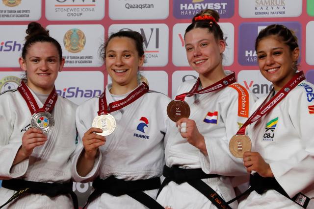 Silver medallist France's Chloe Devictor, gold medallist France's Faiza Mokdar and bronze medallists Netherlands' Shannon Van De Meeberg and Brazil's Sarah Souza celebrate during the podium ceremony for the women's under 57 kg event at the Astana Grand Slam judo tournament in Astana on May 8, 2026. (Photo by STANISLAV FILIPPOV / AFP)