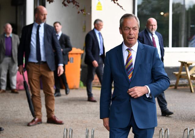 Reform UK leader Nigel Farage reacts during a visit to St Helens, north west England on May 8, 2026, as votes continue to be counted following local elections. Nigel Farage, leader of the Britain's hard-right nationalist Reform UK party, vowed Friday it was "here to stay" after winning hundreds of seats in local polls. (Photo by PETER POWELL / AFP)