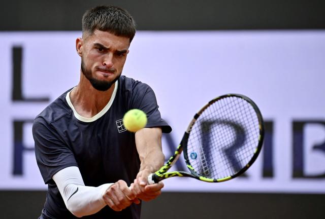 Croatia's Dino Prizmic plays a backhand return to Serbia's Novak Djokovic during their men's singles match of the WTA Rome Open tennis tournament at the Foro Italico in Rome on May 8, 2026. (Photo by Filippo MONTEFORTE / AFP)