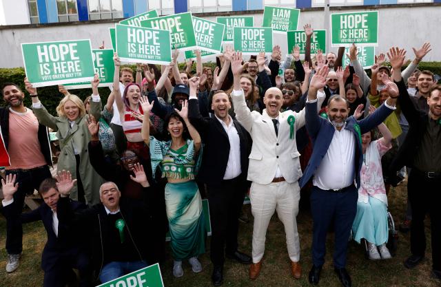 Green Party leader Zack Polanski (C) celebrates with the party's newly elected Mayor of Lewisham, Liam Shrivastava (centre R), and supporters, outside the count centre in Lewisham, south London on May 8, 2026. Nigel Farage's anti-immigrant Reform UK and the left-wing Greens, led by self-described eco-populist Zack Polanski, werw expected to benefit from widespread disillusionment. (Photo by Brook Mitchell / AFP)