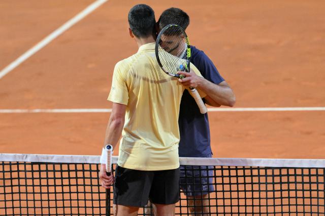 Croatia's Dino Prizmic (R) embraces Serbia's Novak Djokovic after winning their men's singles match of the WTA Rome Open tennis tournament at the Foro Italico in Rome on May 8, 2026. (Photo by Tiziana FABI / AFP)